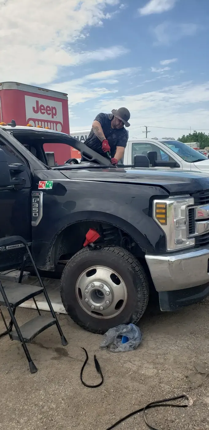 Before — technician installing a new windshield on a Ford Super Duty